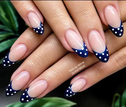 Pale pink nails with navy polka-dot tips