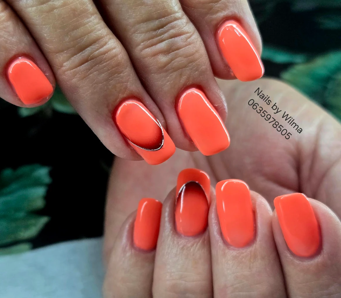 Neon coral nails with glitter wave accent